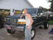 1974 Ford F-100 - A man poses with his lifted Ford F-150 pickup truck in front of a garage.