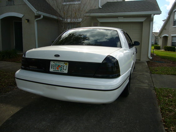 Rear view of a white 2000 Ford Crown Victoria with tinted tail lights and a Florida license plate