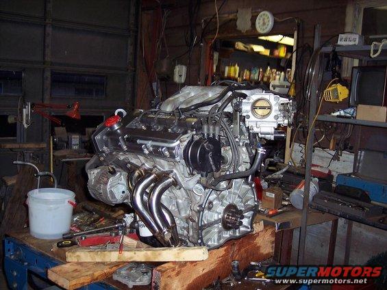 Engine with chrome headers and intake manifold on workbench