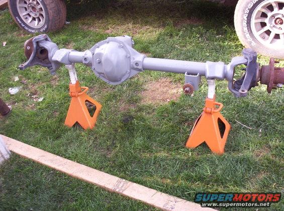 Rear axle assembly on orange jack stands outdoors