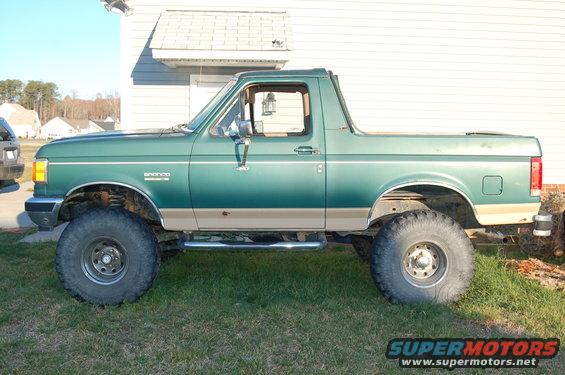 Green 1987 Ford Bronco side view, lifted with large tires