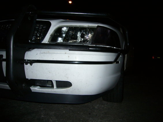 White 2000 Ford Crown Victoria front bumper with a black push bar and fog lights, viewed from a low angle