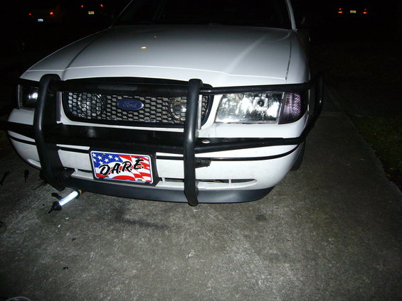 Front view of a white Ford Crown Victoria with a push bar and a D.A.R.E. license plate