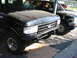 1991 Ford Bronco - 1991 Ford Bronco and another SUV parked under a carport.