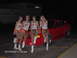 2004 Ford Mustang - Four women in Hooters uniforms pose with a red 2004 Ford Mustang coupe.