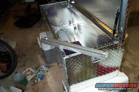 Diamond plate toolbox with open lid and gas strut