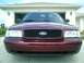 2004 Ford Crown Victoria - Frontal view of a maroon Ford Crown Victoria with a honeycomb grille.