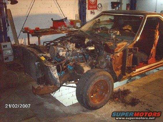 1979 Ford Ranchero disassembled in garage, engine exposed, front end removed