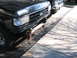 1991 Ford Bronco - Front view of a black Ford truck with a chrome grille and a custom bumper extension.