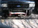 1991 Ford Bronco - The front grille and headlights are consistent with a 1991 Ford Bronco, a prominent Ford emblem and a custom bumper.