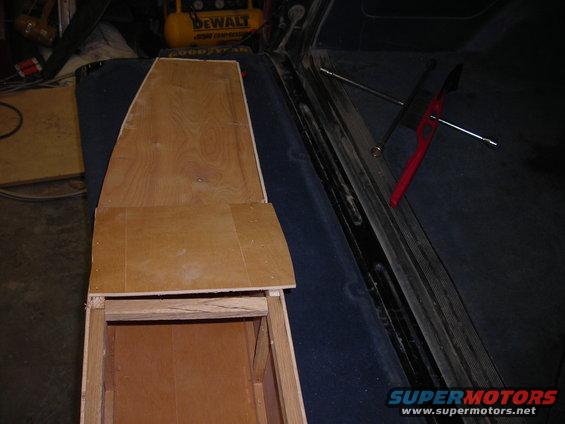 Custom wooden center console being built inside a vehicle. Tools are visible nearby