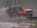 1989 Ford Bronco - A Jeep Wrangler navigates a dusty off-road course with orange and white markers.