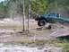 1989 Ford Bronco - Off-road event with a green pickup truck navigating a dirt obstacle course.