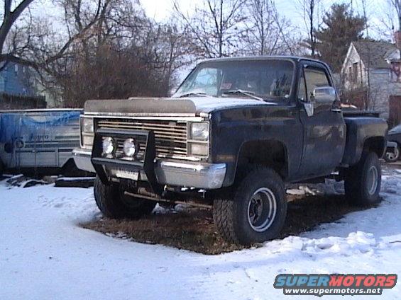 Black pickup truck, front view, with bull bar and fog lights