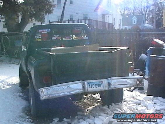 Green pickup truck parked in snow, rear view. License plate reads 41C-090