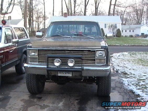 Truck front view, grille, bumper with lights, license plate 4TL-090, brown hood cover