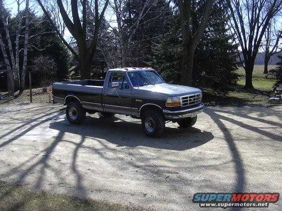 Gray and black 1992 Ford F-250 pickup truck parked on a dirt lot
