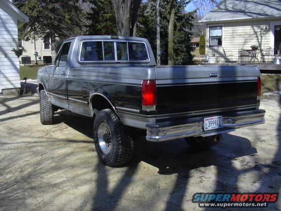 1992 Ford F-250 pickup truck, rear view, two-tone paint, lifted suspension, Wisconsin license plate 399911