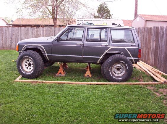 1987 Jeep Cherokee on jack stands with large tires, side view