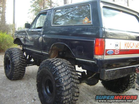 Rear view of a lifted 1989 Ford Bronco with large off-road tires and 'ROCKWELL' decal