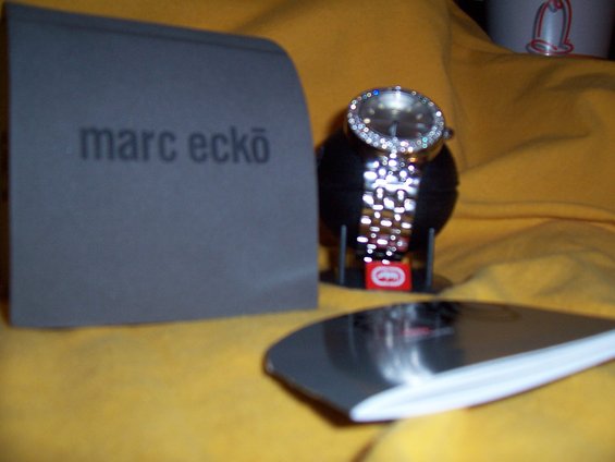 Marc Ecko watch with diamond bezel on display stand next to its box