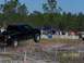 1989 Ford Bronco - Pickup truck airborne during an off-road event, with a crowd watching.