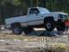1989 Ford Bronco - A white pickup truck navigates an off-road obstacle course.