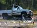 1989 Ford Bronco - This white pickup truck, likely a 1989 model based on its body style, is shown tackling an obstacle course on rocks.
