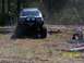 1989 Ford Bronco - A white SUV navigates an off-road course with logs and orange markers.