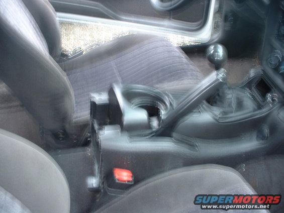Interior view of a car's center console showing the gear shifter and part of the seats