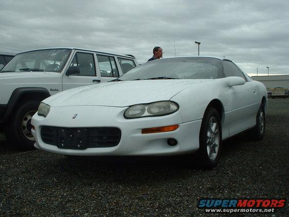 Front view of a white 1998 Chevrolet Camaro parked next to a white Jeep Cherokee