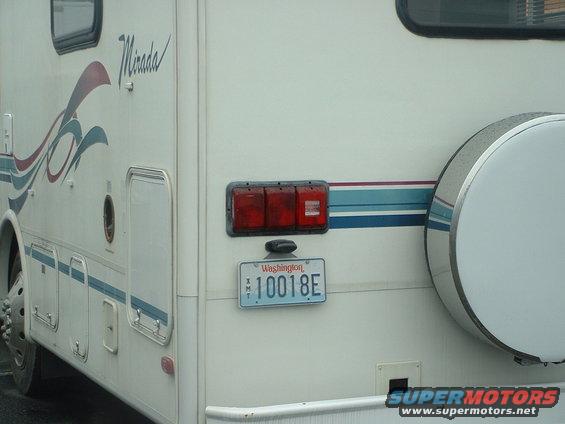 RV rear with triple taillights, spare tire cover, and Washington license plate 10018E