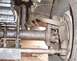 1990 Ford Bronco - Undercarriage view of vehicle suspension and steering parts, covered in grease.