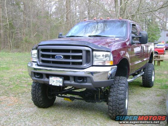 Maroon 2004 Ford F-350 pickup truck, front 3/4 view, lifted with large tires