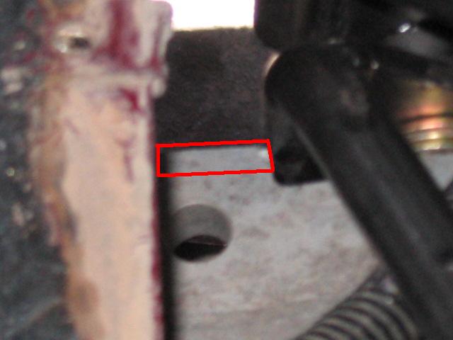 Close-up of a metal part with a red rectangle highlighting a faint marking
