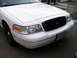 1999 Ford Crown Victoria - Front view of a white 1999 Ford Crown Victoria, a black grille and a visible license plate.