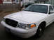 1999 Ford Crown Victoria - Front view of a white Ford Crown Victoria, likely a 1998 model, parked outdoors.
