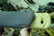 1993 Ford Bronco - A gray fabric arm rest, wrapped in yellow tape, is held by a person's hand in a workshop.