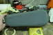 1993 Ford Bronco - A gray armrest part is held by a hand with a roll of tape and other items in the background.