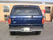 1995 Ford Bronco - Rear view of a blue 1995 Ford Bronco parked outside a building.