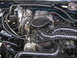 1995 Ford Bronco - Close-up view of a vehicle's engine bay, showing various components and hoses.