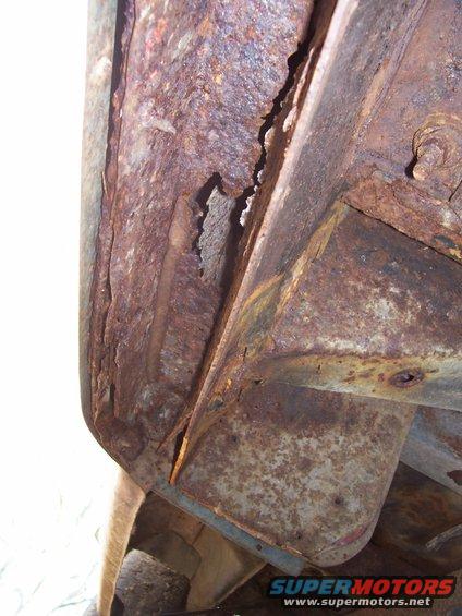 Heavily rusted metal frame section with visible corrosion and damage