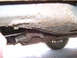 1999 Ford Crown Victoria - The underbody of a vehicle displays significant rust and corrosion, with a visible tire and exhaust system.
