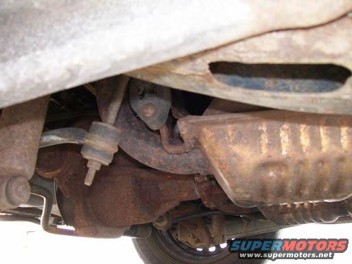 1999 Ford Crown Victoria underbody, showing rusted exhaust components and suspension parts