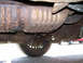 1999 Ford Crown Victoria - The underside of a vehicle reveals significant rust on its exhaust system and other components.