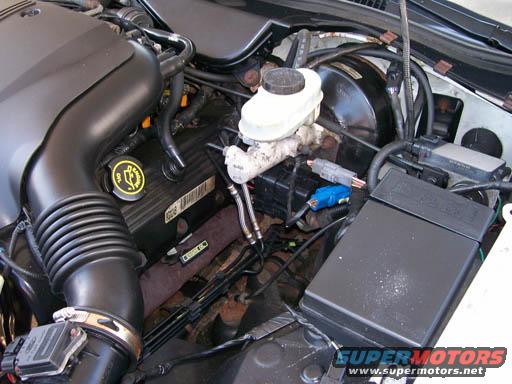 Engine bay with air intake, brake booster, and fuse box visible