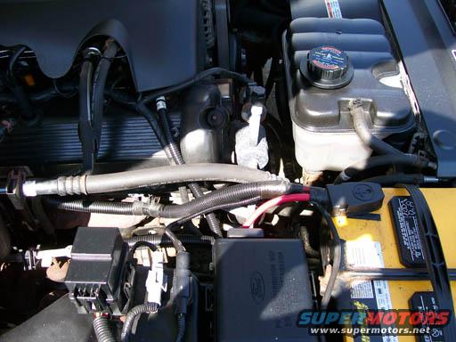 Engine bay with coolant reservoir and battery. Ford logo visible on fuse box