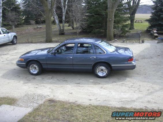 Blue sedan parked outside with a silver pickup truck in the background