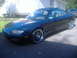 1996 Mazda MX-6 - Dark blue 1996 Mazda MX-6 coupe with aftermarket wheels parked outdoors.