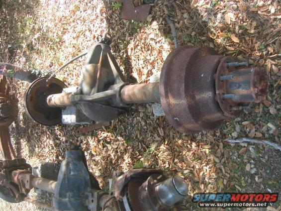 Two rusty rear axle assemblies on the ground